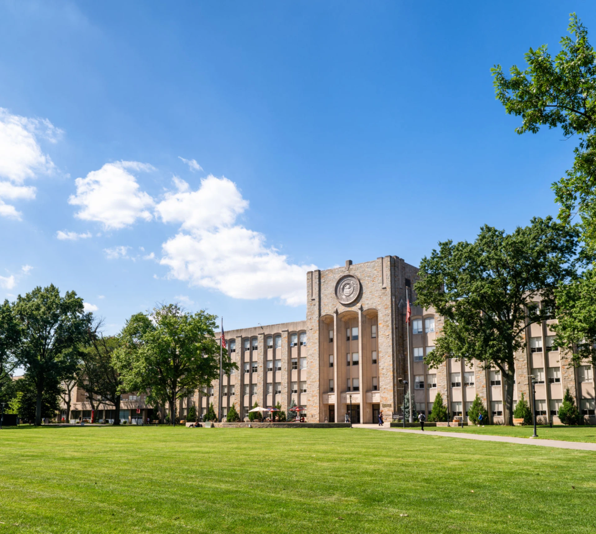 University building with clock tower and trees.