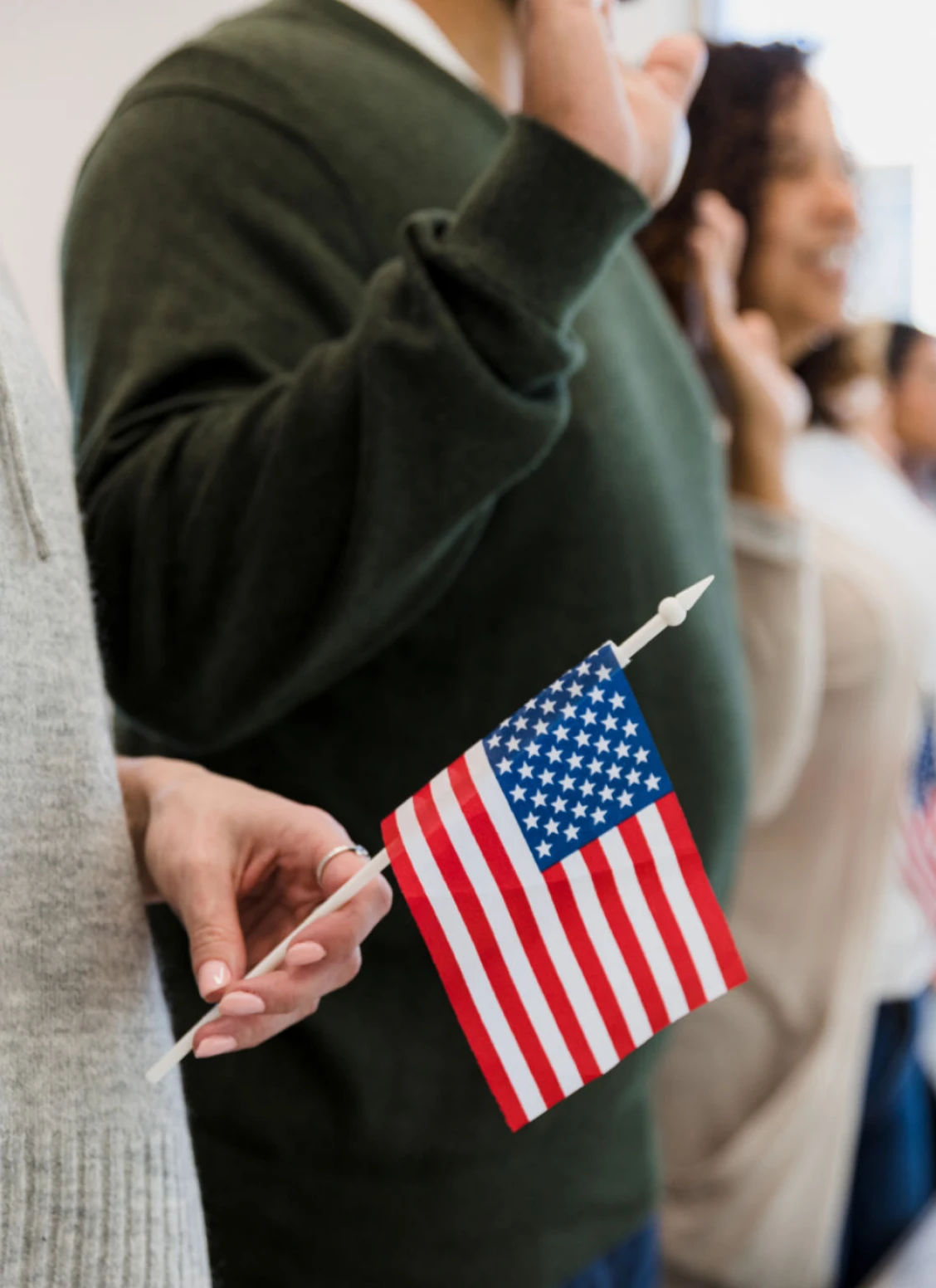 Group pledging allegiance with small U.S. flags